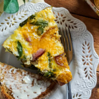 Ham, Asparagus, and Potato Frittata on a plate next to buttered toast and juice.