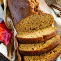 A loaf of Downeast Maine Pumpkin Bread, sliced and sitting on a baking tray.