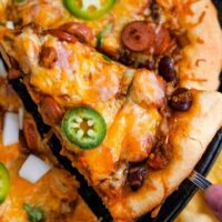 Chili Dog Pizza--Pizza dough is topped with chili, sliced hot dogs and shredded cheese for a quick and easy leftover makeover your whole family will love. #chilidogpizza #chilicheesedogs #pizza #chilidogs