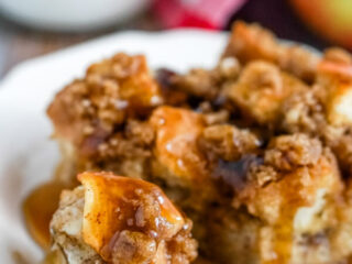 A close up image of a bite of french toast casserole dripping with syrup.