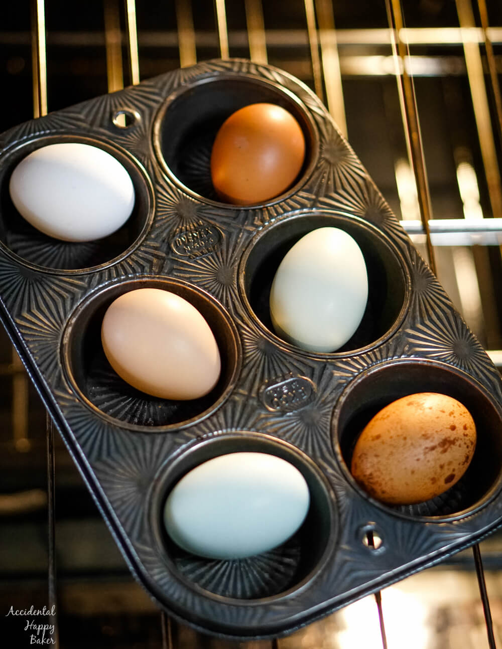 Colorful farm eggs in a muffin tin on an oven rack. 